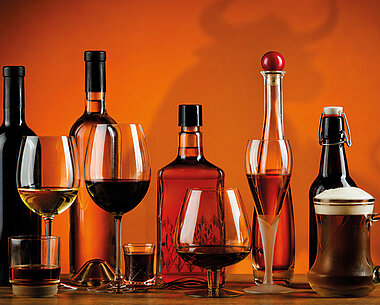 EffectenSpiegel-Thema-der-Woche-ES44web_Site-verschiedener-Alkohol-in-Flaschen-und-Glaesern-mit-dem-Schatten-eines-Bullen-im-Hintergrund